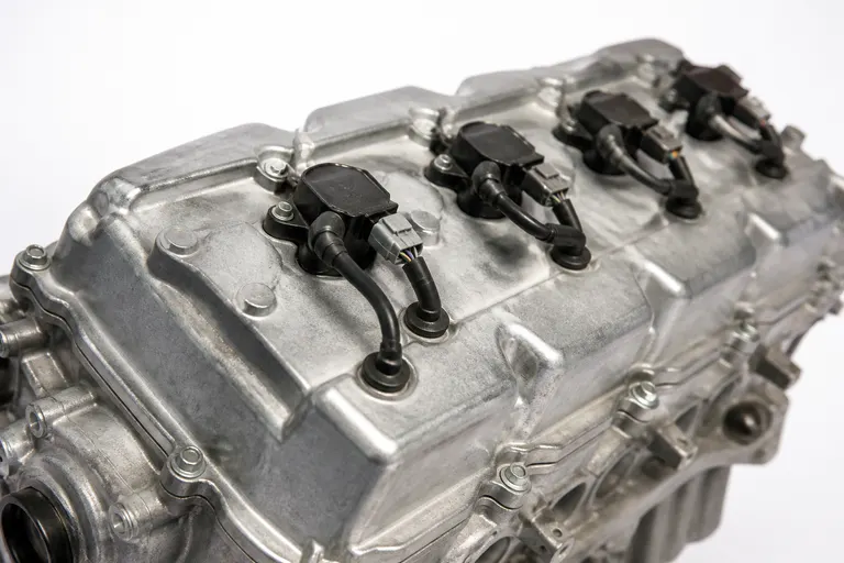 Top of a V8 cylinder head cover with coil-on-plug ignition coils, on a white background
