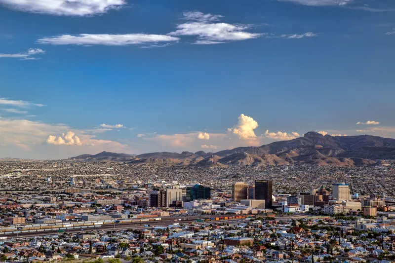 El Paso seen from Scenic Drive: downtown towers and rail yards below desert mountains under a blue sky
